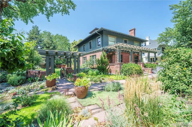 rear view of house with a pergola, a chimney, and brick siding