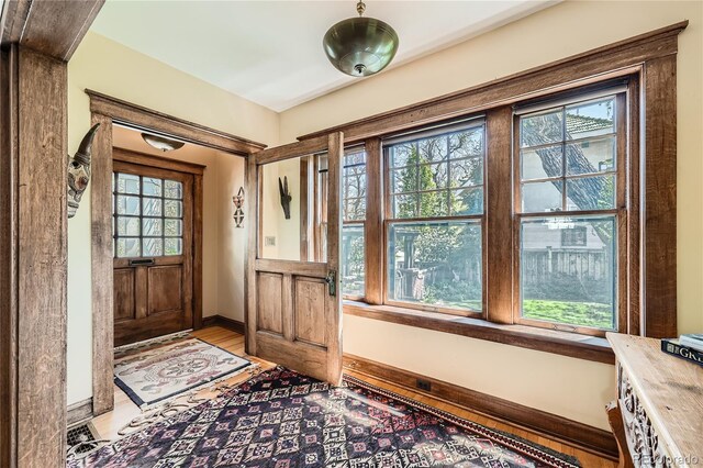 entrance foyer with healthy amount of natural light, light wood-style floors, and baseboards
