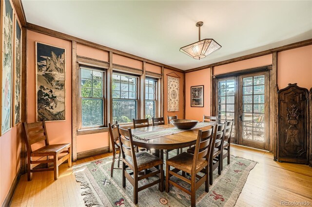 dining room with light wood-style floors, french doors, baseboards, and ornamental molding