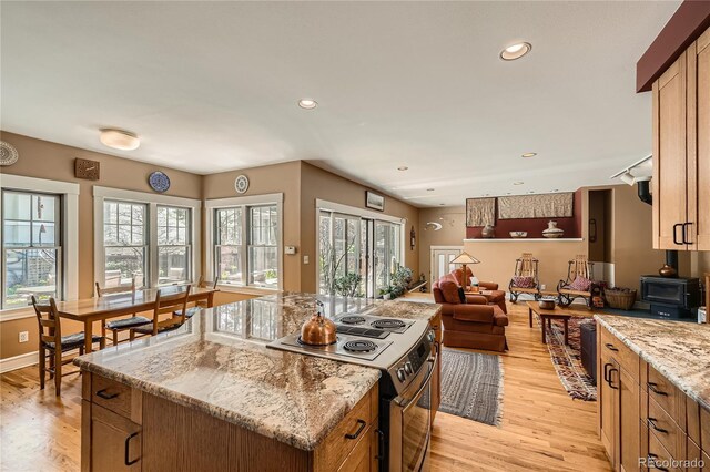 kitchen featuring stainless steel range with electric stovetop, light wood-style flooring, plenty of natural light, open floor plan, and recessed lighting