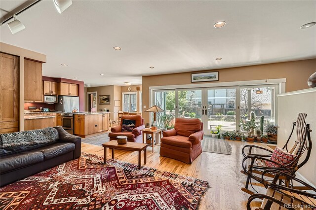 living room with light wood-style flooring and recessed lighting