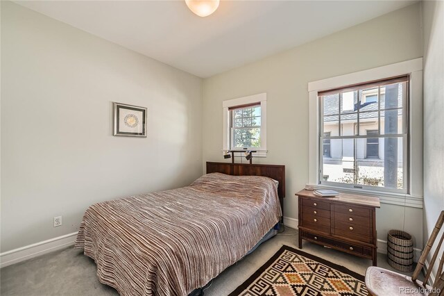 bedroom featuring light colored carpet and baseboards