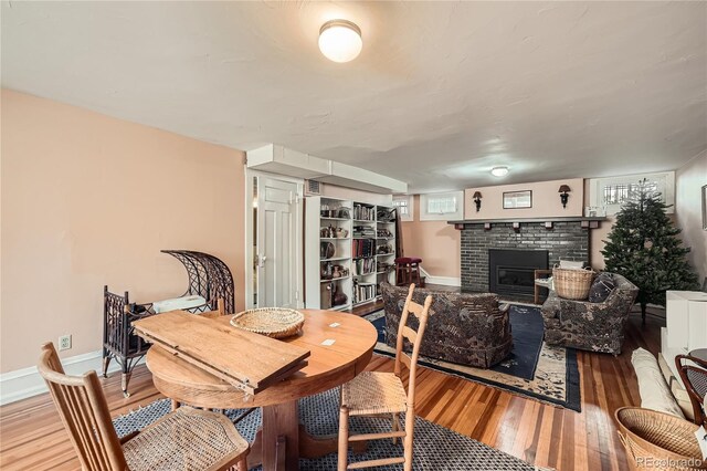dining area featuring baseboards, a fireplace, and wood-type flooring