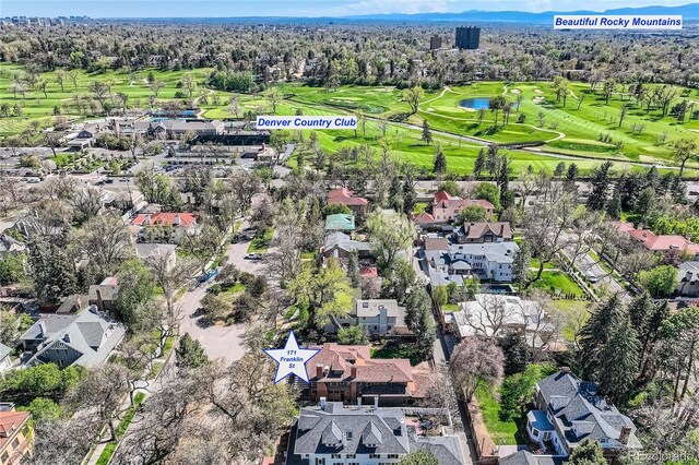 aerial view of property's location featuring a golf club, a nearby body of water, and nearby suburban area