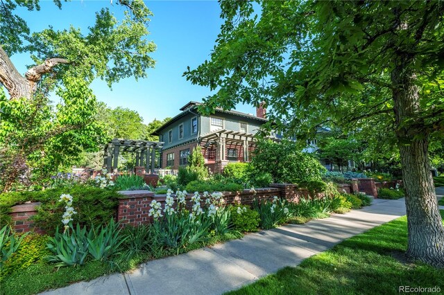 view of home's exterior with a pergola and a chimney