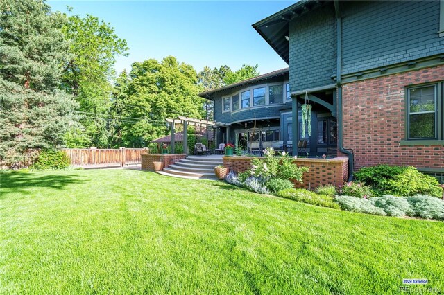 view of yard with a pergola and fence