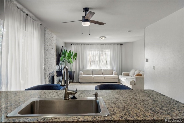 living room with ceiling fan and a textured wall