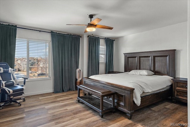 bedroom featuring multiple windows, ceiling fan, and wood finished floors