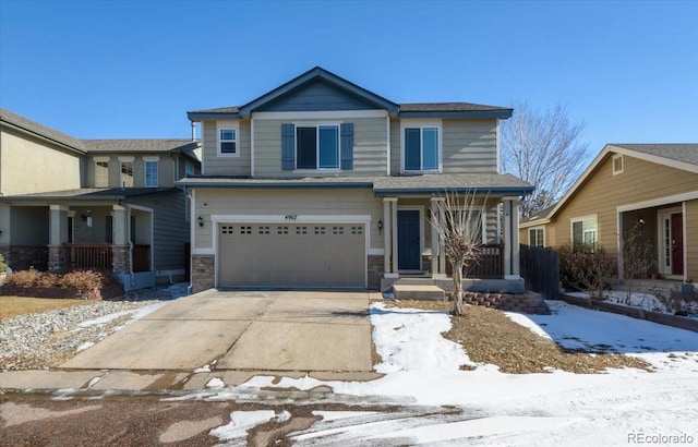 view of front of home with a garage, stone siding, driveway, and covered porch