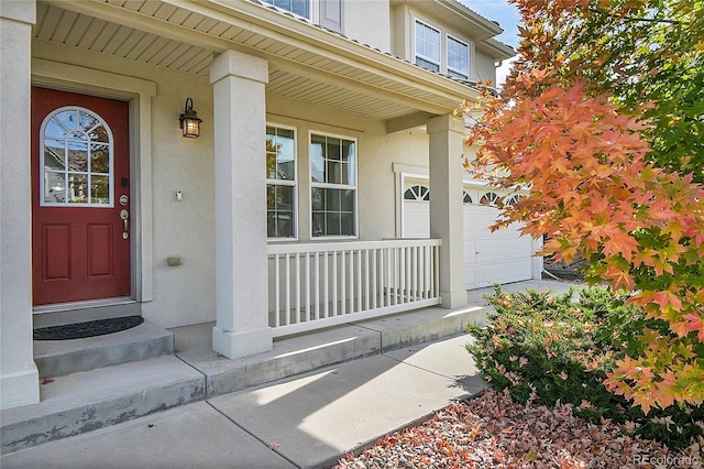 doorway to property with a garage and covered porch