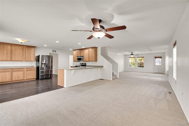 unfurnished living room featuring ceiling fan and dark wood-type flooring