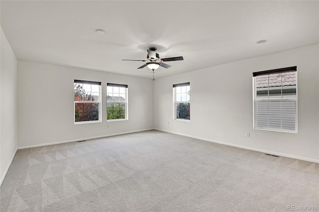 carpeted spare room featuring ceiling fan