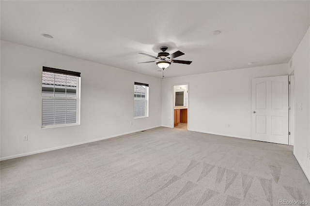 carpeted spare room with ceiling fan