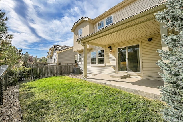 rear view of house featuring a yard and a patio