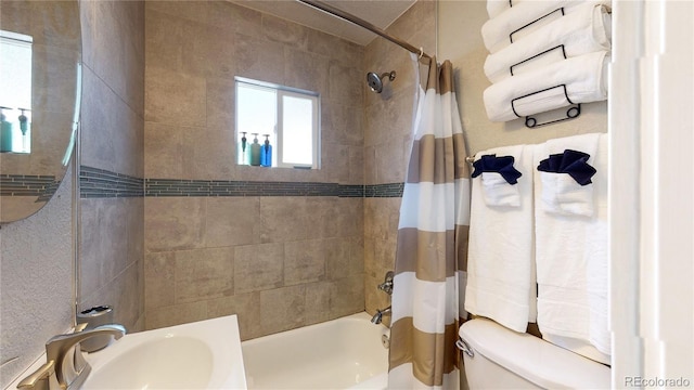 bathroom featuring shower / tub combo, a sink, and toilet