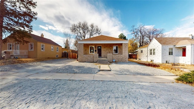 bungalow featuring covered porch and fence