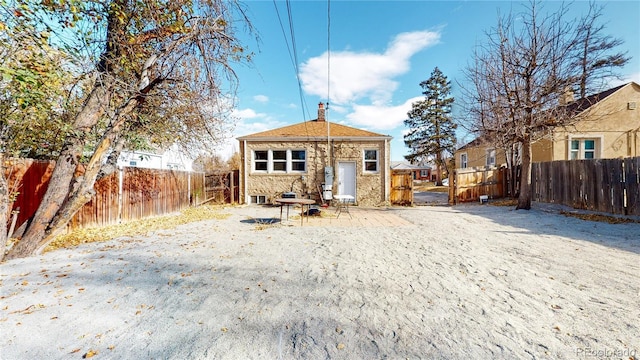 rear view of house featuring a fenced backyard