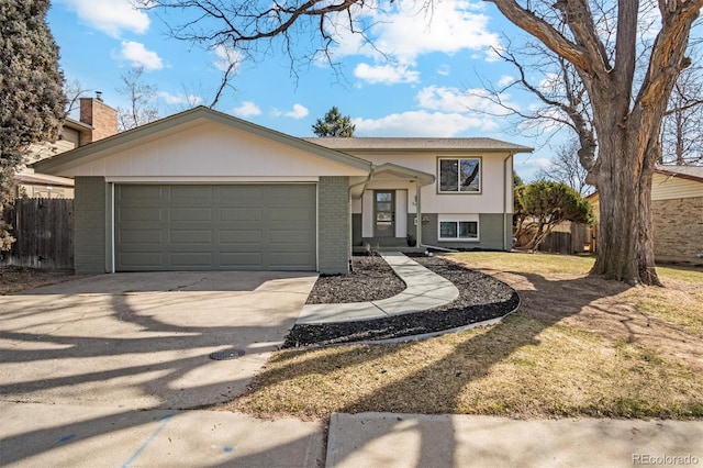 view of front of property featuring a garage, brick siding, driveway, and fence