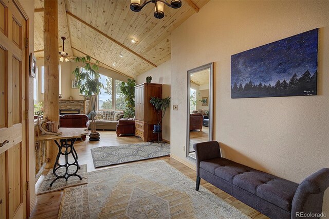 114 Star Ln, Bailey, CO 80421 - living room featuring light wood-style floors, high vaulted ceiling, a fireplace, beam ceiling, and wood ceiling