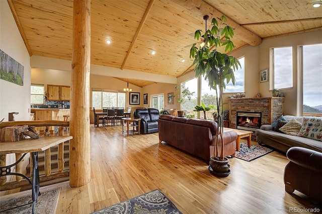 114 Star Ln, Bailey, CO 80421 - living area with beamed ceiling, light wood-type flooring, a chandelier, wood ceiling, and a glass covered fireplace
