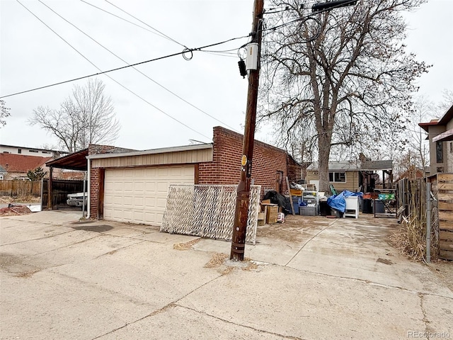 exterior space with a detached garage, an outdoor structure, and fence