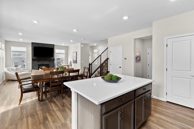 138 Lullaby Ln, Castle Rock, CO 80109 - kitchen with a fireplace, wood finished floors, light countertops, dark brown cabinets, and open floor plan
