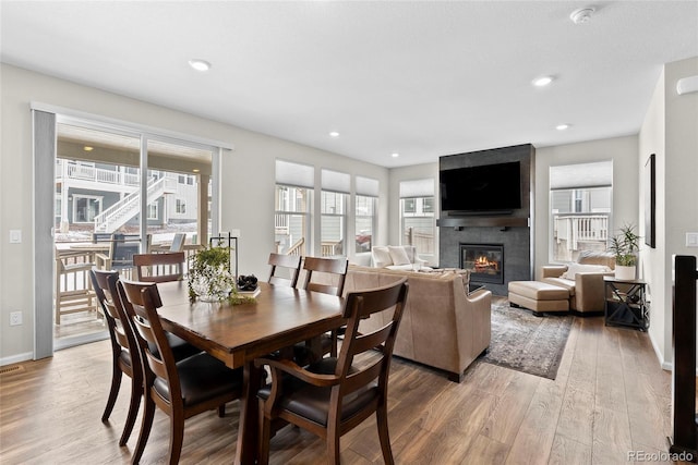 138 Lullaby Ln, Castle Rock, CO 80109 - dining space featuring a large fireplace, light wood-type flooring, baseboards, and recessed lighting