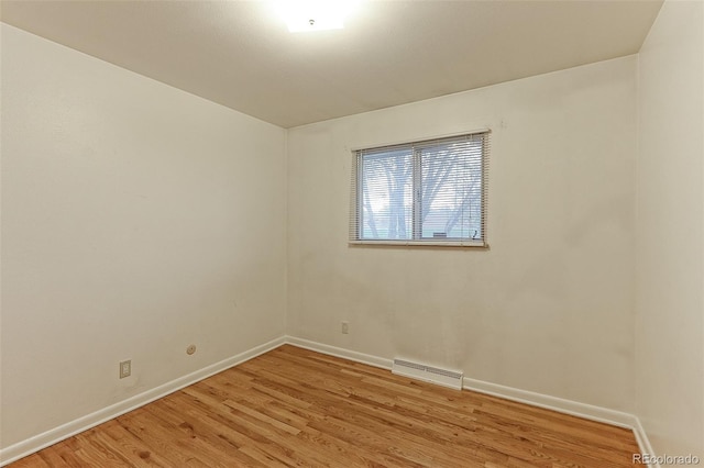 empty room with light wood finished floors and baseboards