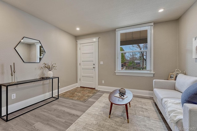 living room featuring baseboards, recessed lighting, and wood finished floors