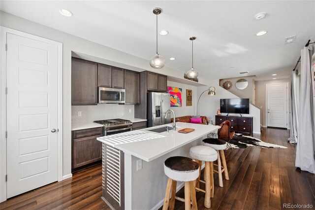 2449 Foerster Grass Vw, Colorado Springs, CO 80915 - kitchen featuring dark wood finished floors, a kitchen breakfast bar, light countertops, appliances with stainless steel finishes, and open floor plan