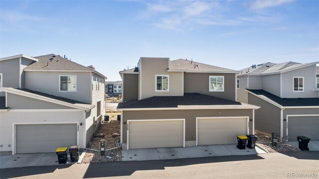2449 Foerster Grass Vw, Colorado Springs, CO 80915 - multi unit property featuring a residential view, an attached garage, a shingled roof, and driveway