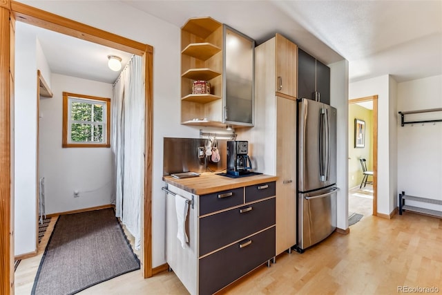 kitchen featuring butcher block counters, light hardwood / wood-style floors, and stainless steel fridge