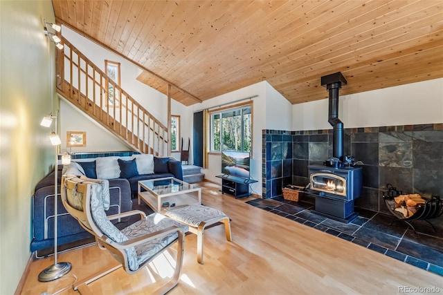 living room featuring hardwood / wood-style floors, wood ceiling, a wood stove, lofted ceiling, and tile walls