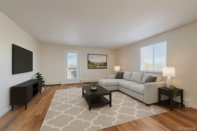 living area with a baseboard radiator, light wood-style flooring, and a baseboard heating unit