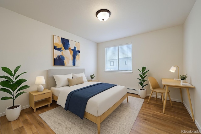 bedroom featuring baseboards, baseboard heating, and light wood-type flooring