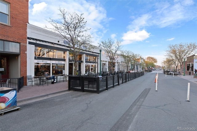 view of street with street lighting, a residential view, sidewalks, and curbs