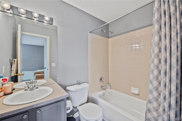 bathroom with a textured wall, shower / bath combination with curtain, toilet, and vanity