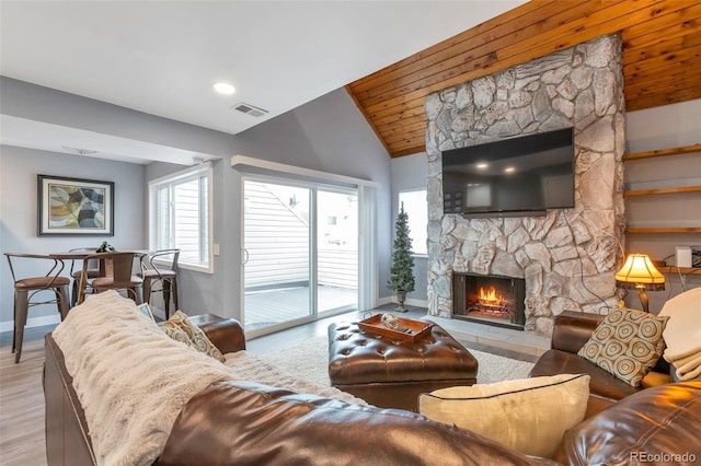 living room with light hardwood / wood-style floors, wood ceiling, a fireplace, and vaulted ceiling