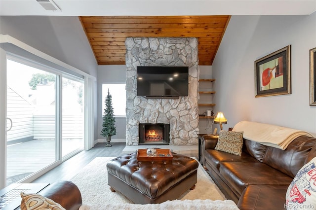 living room with a stone fireplace, wooden ceiling, light hardwood / wood-style flooring, and vaulted ceiling