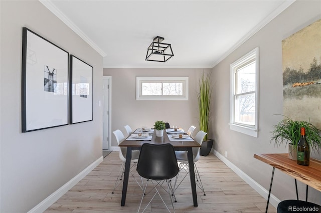 dining area featuring a wealth of natural light, light wood-style floors, and crown molding