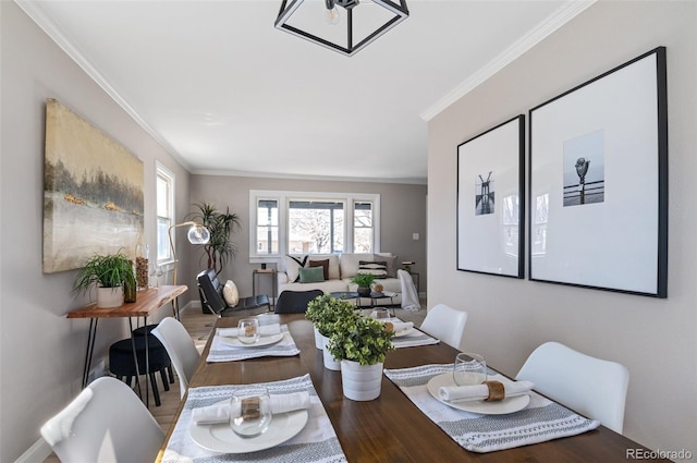 dining room with crown molding and wood finished floors