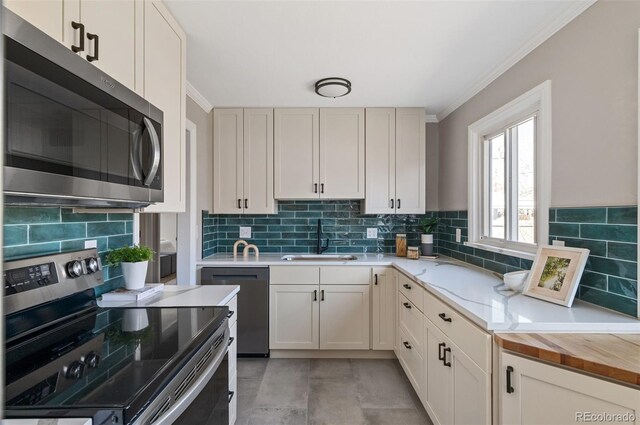 kitchen featuring backsplash, crown molding, stainless steel appliances, wood counters, and a sink