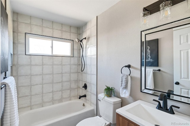 bathroom featuring vanity, toilet, tub / shower combination, and a textured wall