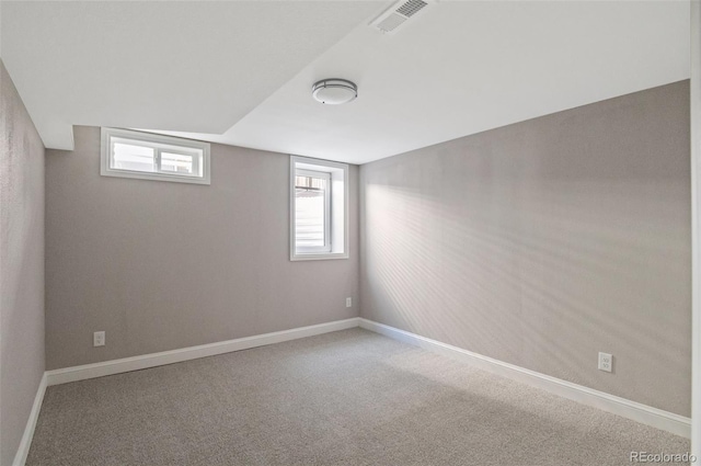 basement featuring visible vents, baseboards, and carpet floors