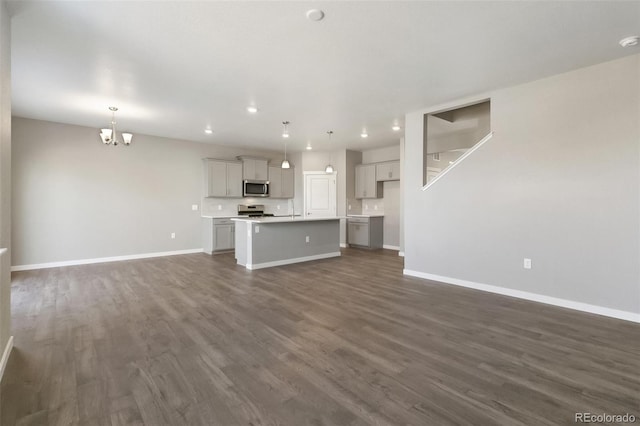 27746 E Byers Pl, Aurora, CO 80018 - unfurnished living room featuring dark wood-style floors, baseboards, a chandelier, and recessed lighting