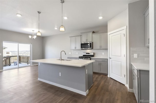27746 E Byers Pl, Aurora, CO 80018 - kitchen with appliances with stainless steel finishes, a sink, gray cabinets, a chandelier, and tasteful backsplash
