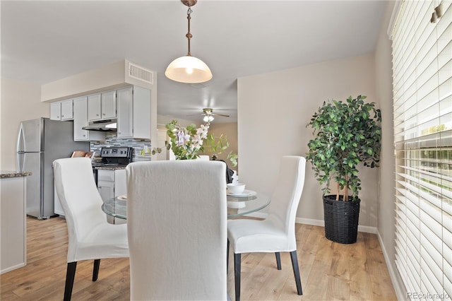 dining room with ceiling fan and light hardwood / wood-style flooring