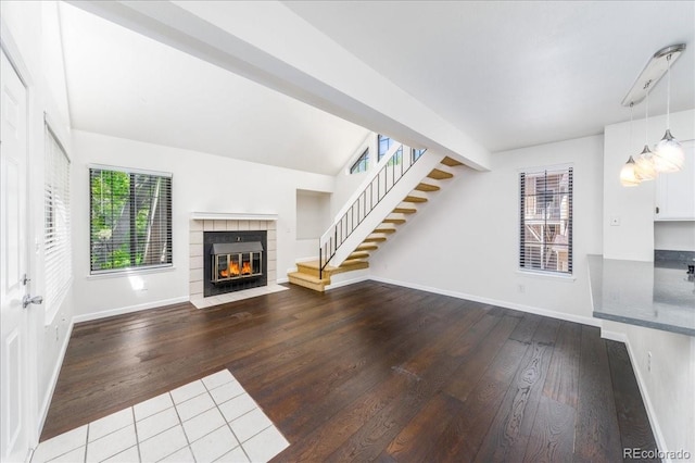 unfurnished living room with hardwood / wood-style flooring, stairway, and baseboards