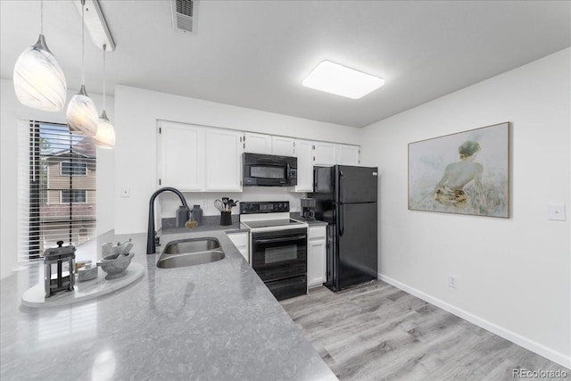 kitchen with visible vents, a sink, black appliances, white cabinets, and pendant lighting