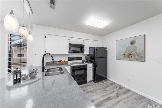 kitchen featuring visible vents, a sink, black appliances, white cabinets, and decorative light fixtures